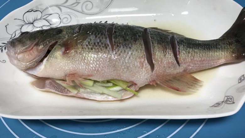 清蒸鲈鱼,在鱼身两面抹上少量<a style='color:red;display:inline-block;' href='/shicai/ 718'>料酒</a>和盐，鱼肚子里塞上适量葱姜丝，腌制10分钟左右。