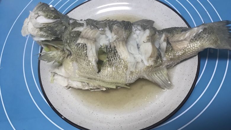 清蒸鲈鱼,鱼出锅倒掉碟子里的汤汁。