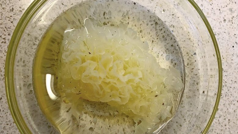雪耳枸杞冰糖水,切1/4放入清水中浸泡5分钟。
如果用干银耳,就要泡发久一些。
