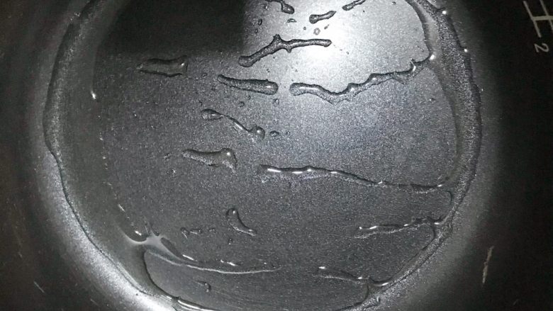 智能电饭煲——酸奶蛋糕,这个时候锅也预热得差不多了,拿出,放少许食用油,然后将油摇匀,像这样的状态
