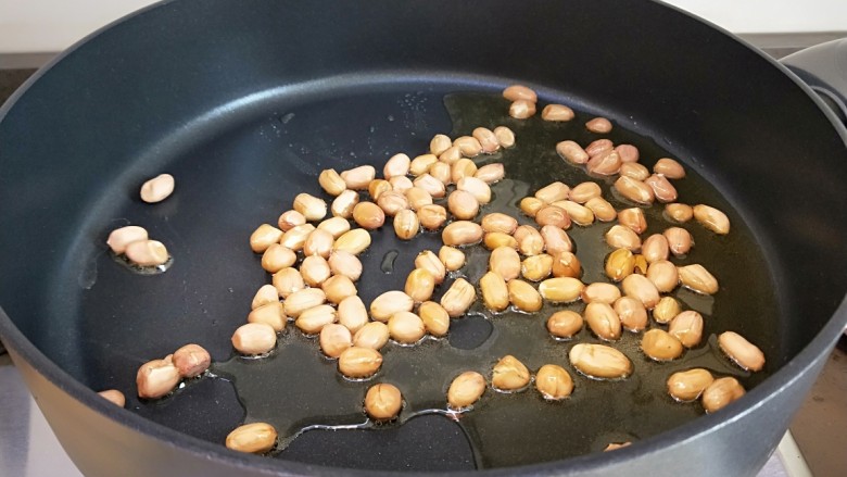 麻辣鸡丁,花生米倒入平底锅小火炸制。
