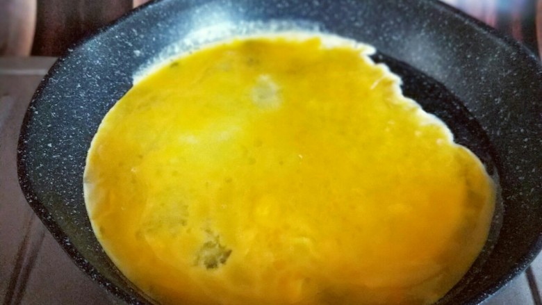 韭菜鸡蛋水饺#附加韭菜不出水秘诀#,起油锅,又热时倒入蛋液,小火煎蛋饼,待蛋液凝固后再将鸡蛋饼切碎。