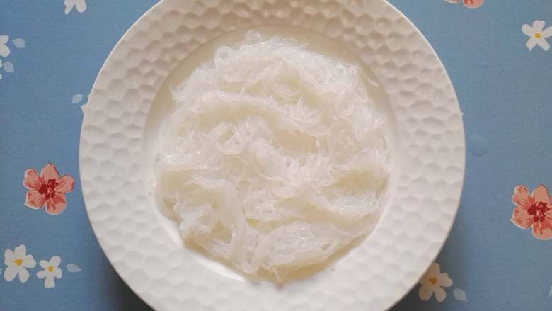 剁椒粉丝蒸虾,取一盘,粉丝铺在盘底。