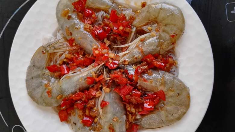 剁椒粉丝蒸虾,汤汁淋在大虾上,蒸锅烧开,将盘子放入锅中蒸4分钟即可。