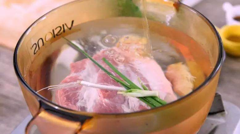 去四川必点名菜——蒜泥白肉,清水下五花肉、姜块、葱、料酒,大火煮开