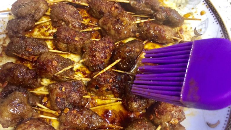 微波炉密技10分钟牙签烤肉,时间到了取出,用刷子沾上盘子里的油料刷再肉上