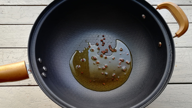【凉拌猪心】 ,锅加油烧热,下入花椒,小火将花椒炸至微焦,将花椒捞出不用