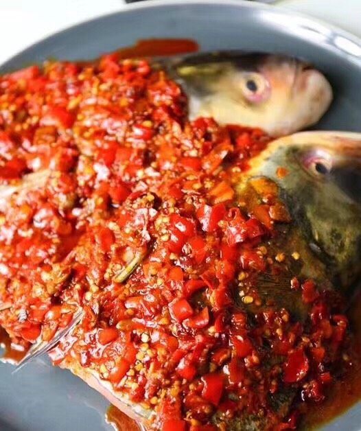 剁椒鱼头,将炒好的剁椒酱均匀的铺在鱼头上