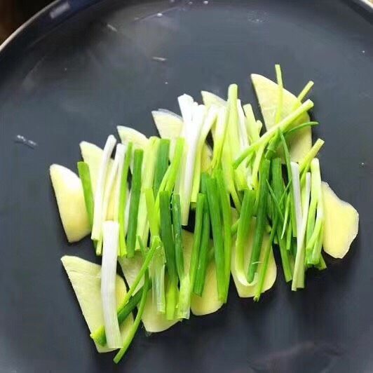 剁椒鱼头,姜切片，葱切段，铺在盘底
