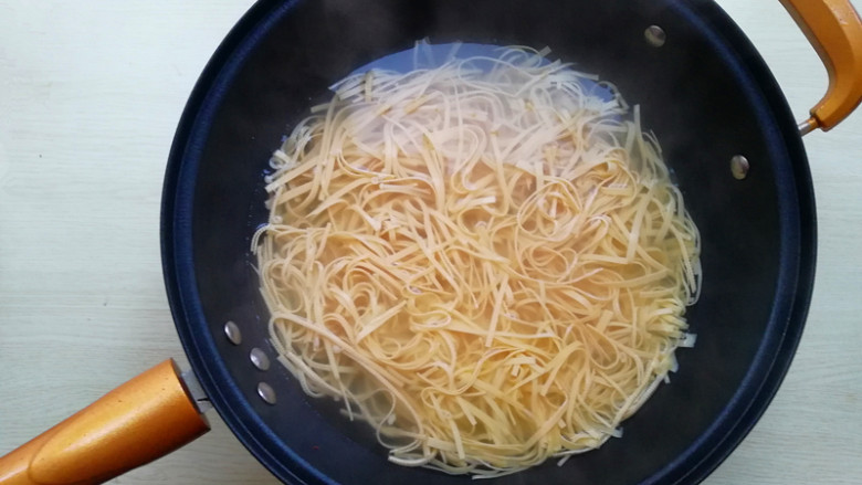 【东北家常凉菜】,锅加水烧开,下入干豆腐焯水2-3分钟