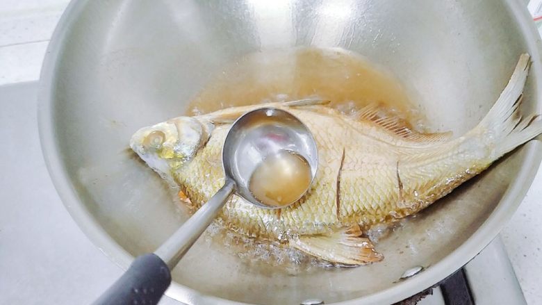 鱼跃龙门年年有余+红烧鳊鱼,煎鱼的时候,用个勺子不停地把油网上淋,使其受热均匀。端起锅,鱼可以晃动的时候,下面就煎好了。