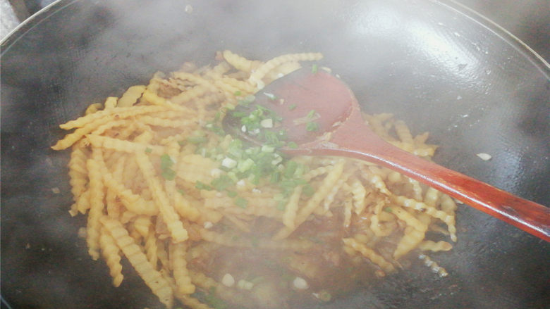 孜然肉末狼牙土豆,汤汁沸腾后,加入葱花翻炒一下,装盘即可,
