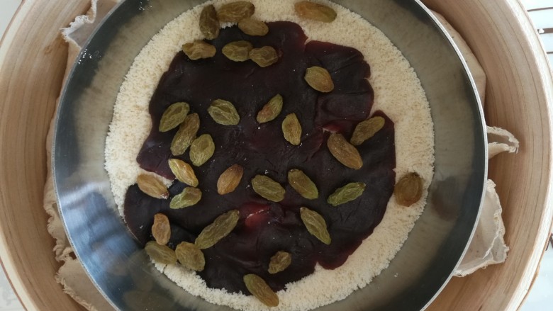 吉祥如意年年糕,然后再铺上一层米粉,剩余的红豆沙,葡萄干