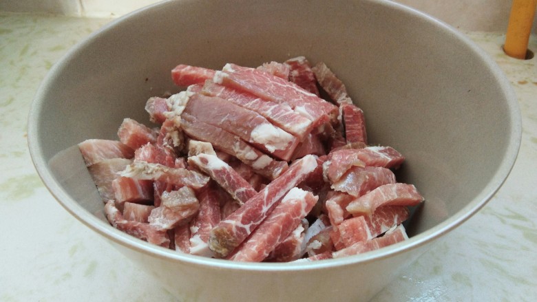 饭桌上爱不释口的美味“糖醋里脊”,<a style='color:red;display:inline-block;' href='/shicai/ 4430'>里脊肉</a>切成长5-7厘米,宽2厘米的条型,找一个干净的大碗装起来。