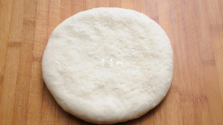 葱香酥脆千层饼干 趁着天冷好开酥,松弛后的面团按扁,撒上一层面粉防粘,从中间向两端均匀的擀开,这一步如果有一个滚轴擀面杖会大大的提高工作效率。