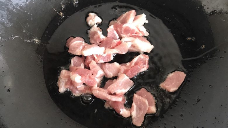 土豆炖豆角,锅中添油，油热放入五花肉煸炒出香味。