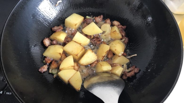 土豆炖豆角,土豆炒至金黄。