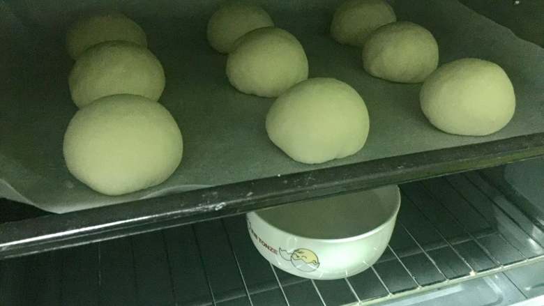 红豆沙餐包,把豆沙包放进烤箱,同时放入一碗热水增加温度和湿度,进行二次发酵。