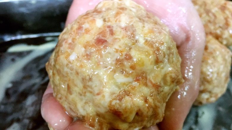 做年货 家宴特色秘制龙眼丸子(31个步骤图文详细解释),用手将鸡蛋淀粉糊涂抹在龙眼丸子上,要均匀涂面。
这步的主要目的是给龙眼丸子穿上一层漂亮的外衣,炸完后它会很漂亮,否则丸子颜色发黑。