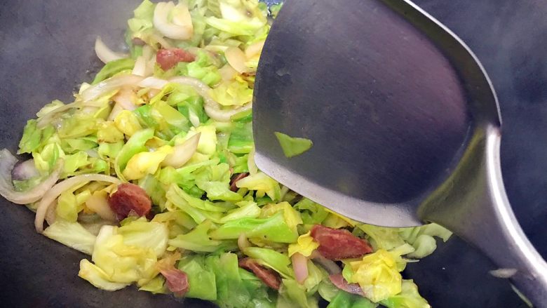 锦衣玉食~圆白菜洋葱炒腊肠,翻炒至汤汁收紧,加一小勺细盐,翻炒均匀,即可