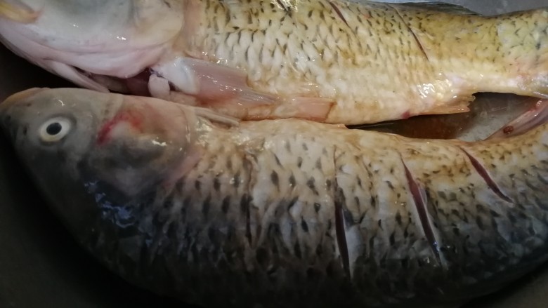 年夜菜_麻辣清蒸江鲫鱼&一锅两吃,把料酒,海鲜酱油也是同样抹到两个鱼身上。