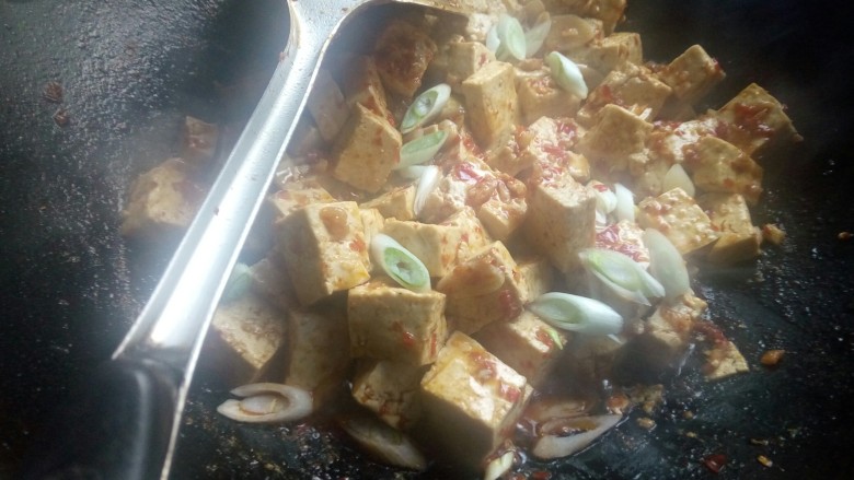 麻婆豆腐(家常版),待锅里汤汁快收干时,倒入水淀粉和葱白快速搅拌