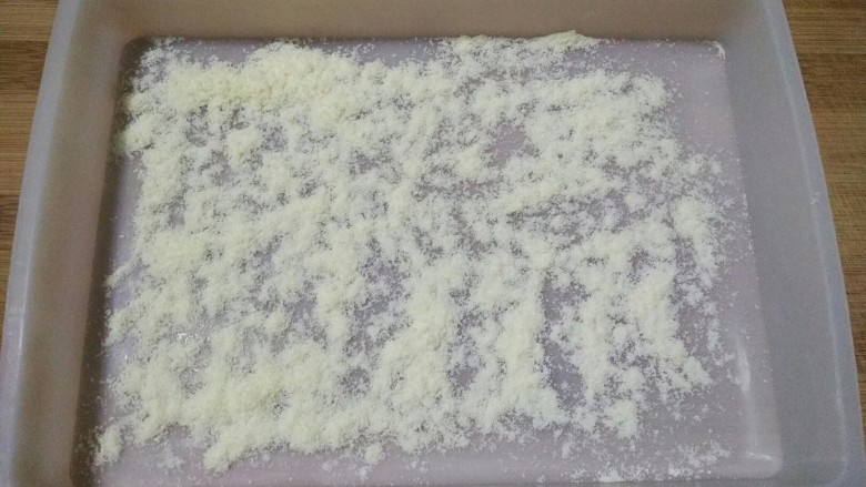 雪花酥――牛轧糖plus(无黄油棉花糖微波炉版),在硅胶容器内底撒一层奶粉。