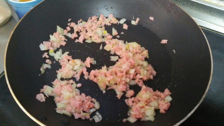 香烤鸡蛋南瓜圈,锅中加少许橄榄油,加入洋葱末和火腿末,翻炒一分钟