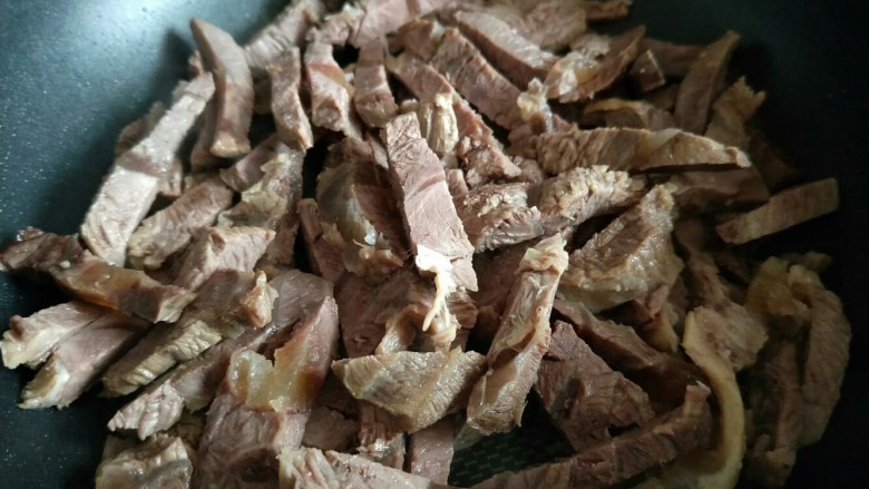 春节招待客人的健康零食~香辣牛肉干~新年新招乐过年,将切好的牛肉条放入平底锅中,小火慢炒,将水份炒干。