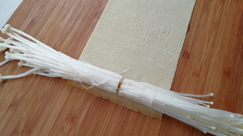 【豆皮金针菇卷】,取一张豆皮,平铺开,两边放上金针菇