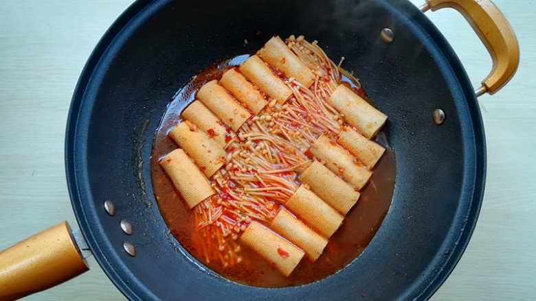 【豆皮金针菇卷】,将豆腐卷翻面,使上下熟制一样