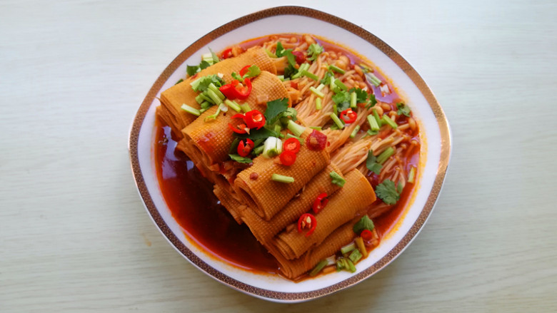 【豆皮金针菇卷】,盛出转圈码在盘内,撒上香菜段和辣椒圈即可