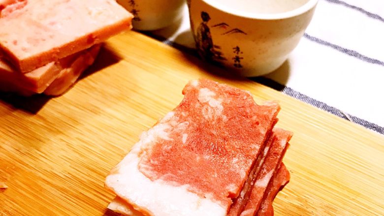 经光波烘焙的韩式部队火锅,取一片培根肉片,均匀切成九段。