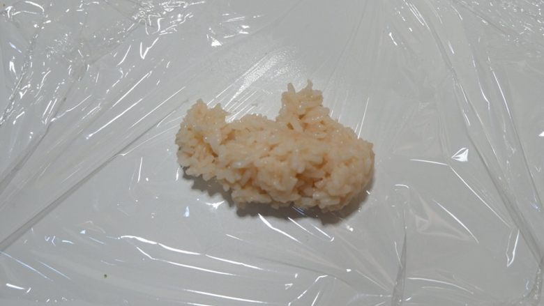 鞭炮齐鸣,娃娃送福,儿童卡通餐,取适量米饭放在保鲜膜上