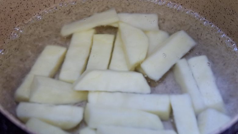 鞭炮齐鸣,娃娃送福,儿童卡通餐,锅中烧开水。放入土豆,将土豆焯至断生。