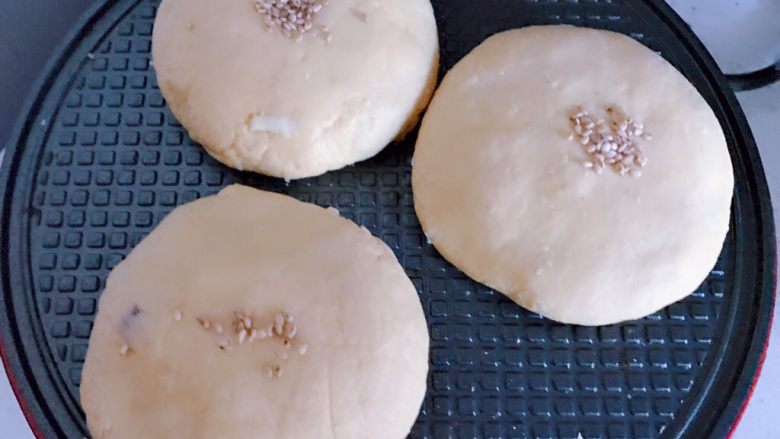 红薯蔓越莓芝士软饼,小红锅刷油预热好,将小饼放入烤盘内,撒上芝麻,烤5分钟取出食用。