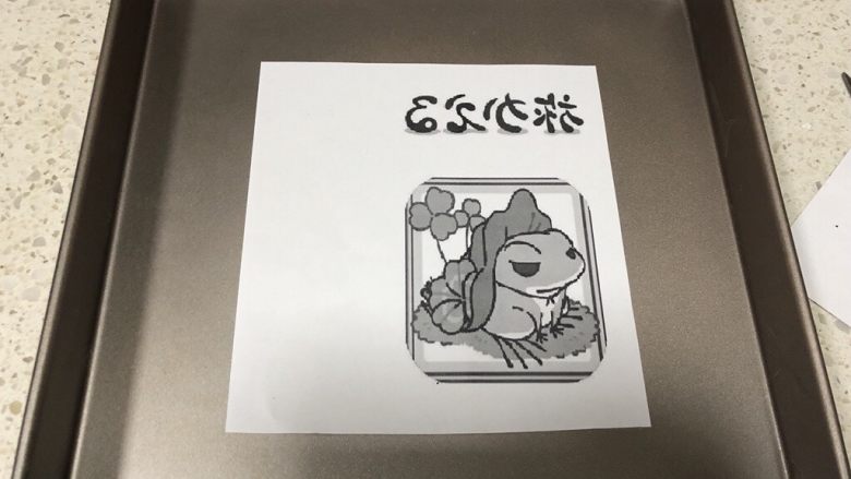 旅行青蛙蛋糕卷,准备工作:需要在电脑上下载一张旅行青蛙的图,然后编辑一下,镜像处理,打印出来,不打印也可以,拿张油纸能在电脑屏幕上画出来轮廓也是可以的。把图案放在28cm*28cm的方盘内的3/4处