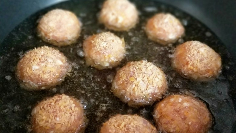 年夜饭~肉糜芝士夹心丸子,一个一个的将丸子放入油锅中。