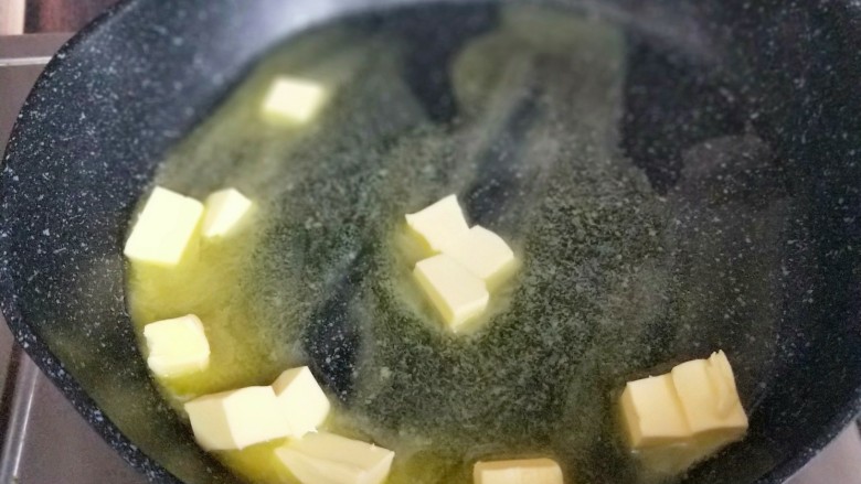 网红~坚果饼干雪花酥,将切小块的黄油放入不粘锅中,小火将黄油融化。