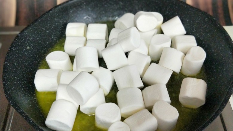 网红~坚果饼干雪花酥,黄油融化后加入棉花糖,不停地翻炒。