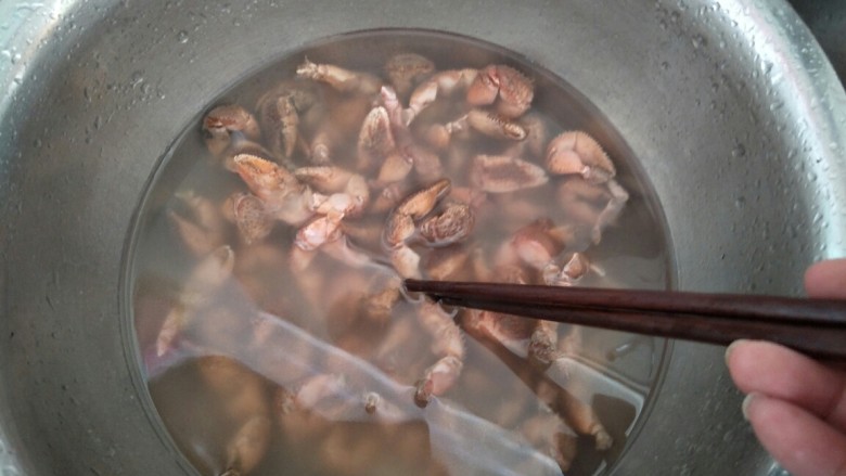 麻辣蟹钳,把蟹钳放在盆中,用筷子使劲搅拌。
