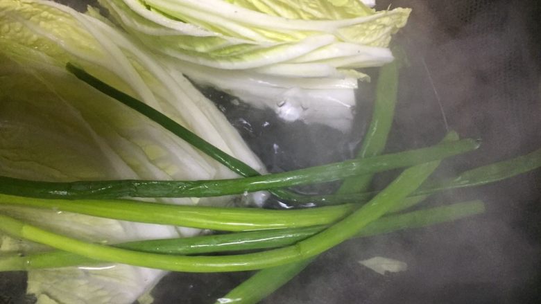 #吉祥菜肴#招财进宝百财福袋,锅里烧水,水开后放入白菜叶和大葱叶