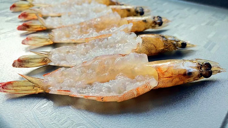 花开富贵虾,虾开背去虾线、虾枪,然后用刀背把虾肉来回剁几下,敲断虾筋。