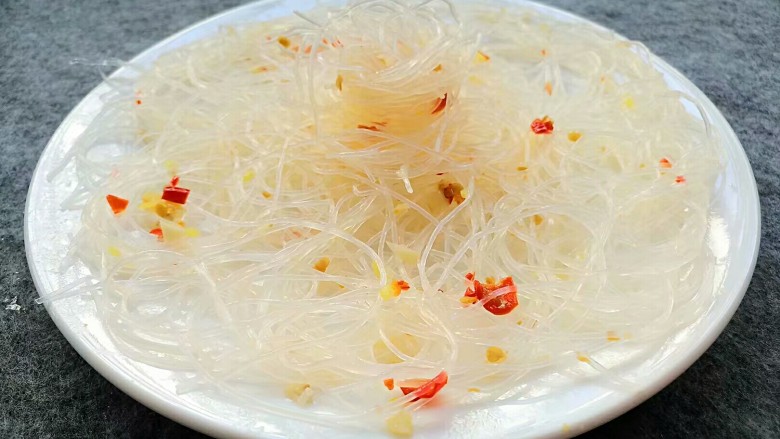 花开富贵虾,夹一半粉丝平铺在盘子上,另一半团成一个球摆在中间。