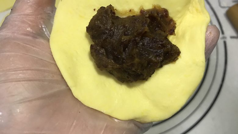旺财柴犬枣泥包,将小剂子按扁后稍微擀圆,然后包入枣泥馅