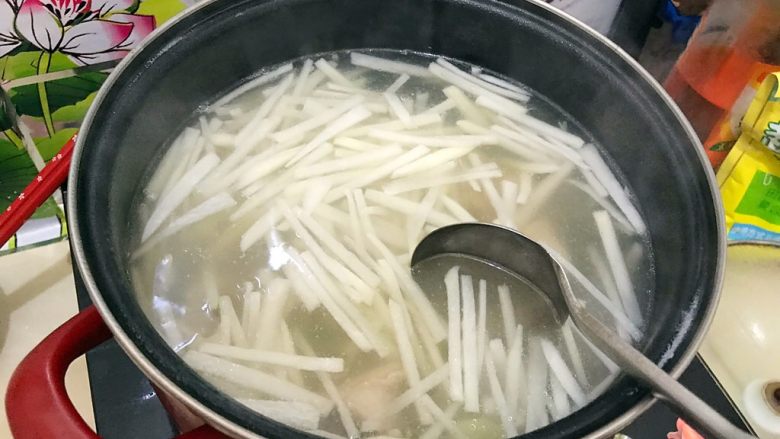 清热解火首选の萝卜丝排骨汤,转中大火,用勺子搅拌一下