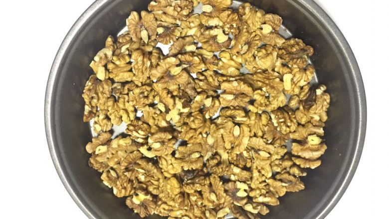 核桃蔓越莓牛轧糖(熬糖版),备好核桃,放入烤箱中层150度15分钟,烤熟核桃,期间翻动核桃