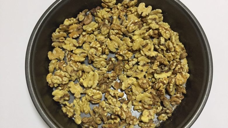 核桃蔓越莓牛轧糖(熬糖版),核桃去皮,核桃去皮不是很好操作,留一点也没有关系,再放入烤箱中层80度保温备用