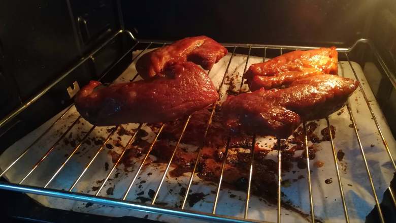 蜜汁叉烧,十五分钟后再次拿出，翻面，再涂上腌制的酱汁，再涂上一层蜂蜜水。