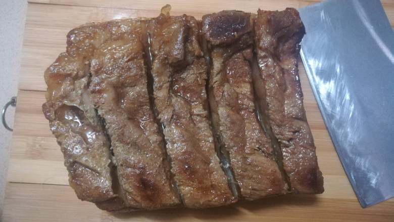脆皮烧肉,在烧肉冷却好后,先按着一开始切的位置切条。切的时候会发现到了猪皮位置很难切下去,这时就用刀直接压下去,会听到很响脆的“咔嚓”一声,然后切成小方块